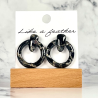 stud earrings shaped like circle door knocker, in black, whi