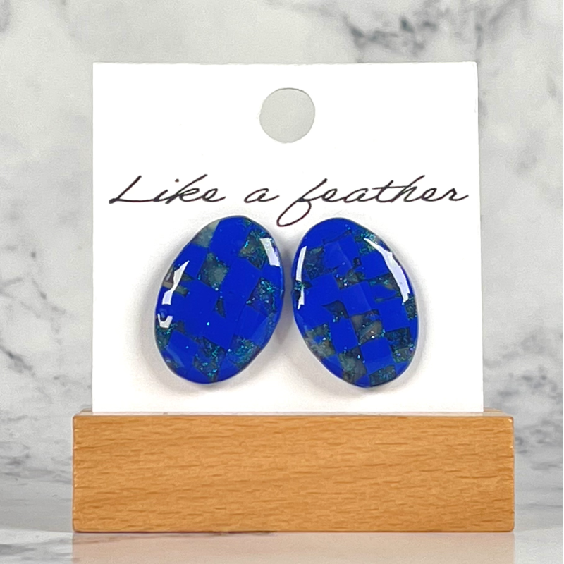 stud earrings shaped like oval, in blue, transparent colors.