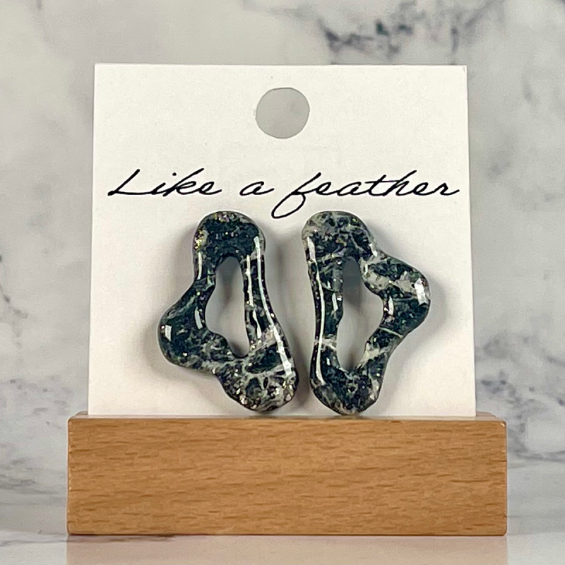 stud earrings shaped like organic, in black, white, silver c