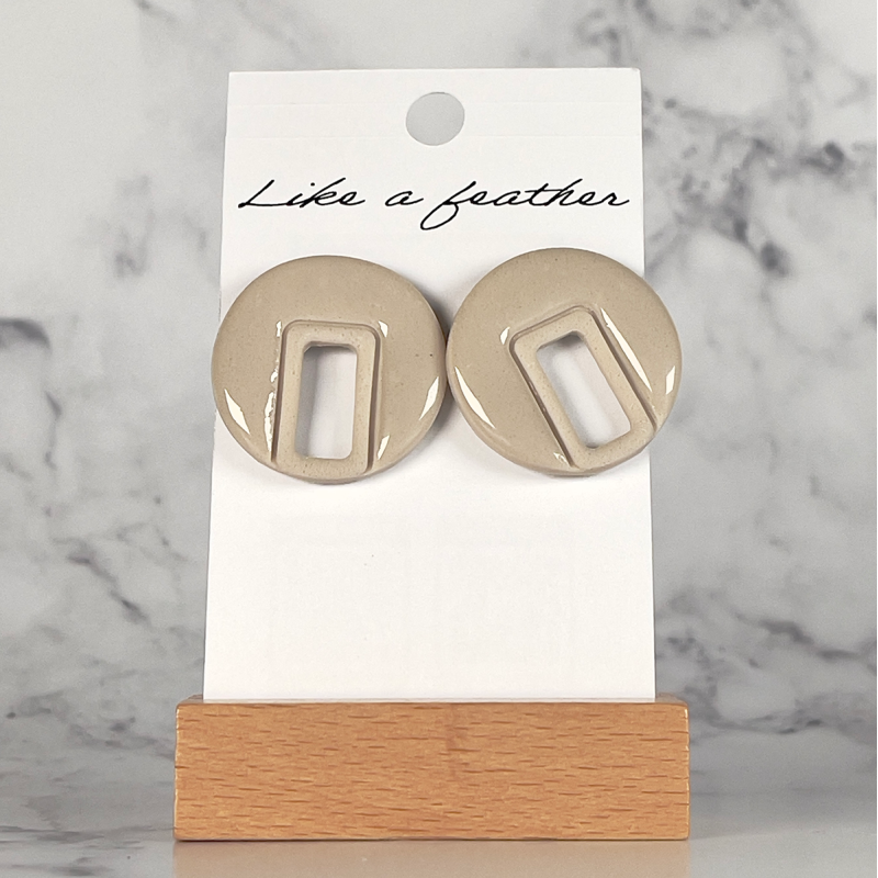 stud earrings shaped like pierced round, in sand color.