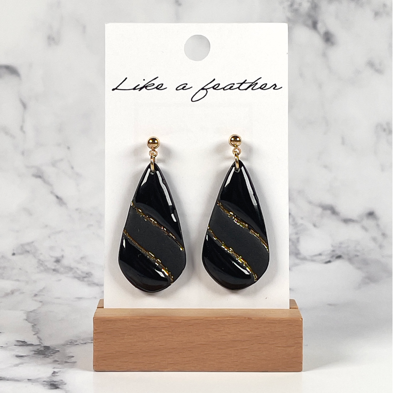 dangling earrings shaped like drop, in black color.
